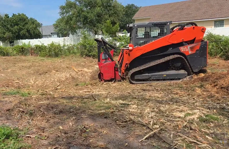 Kubota SVL 97-3 tracked skid steer with forestry mulcher attachment clearing a residential lot in Jacksonville FL — 904Tree