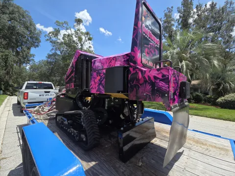 904Tree pink camo tracked stump grinder loaded on a blue equipment trailer showing the Got Stumps? 904TREE.com branding, ready to roll to the next Jacksonville, FL job